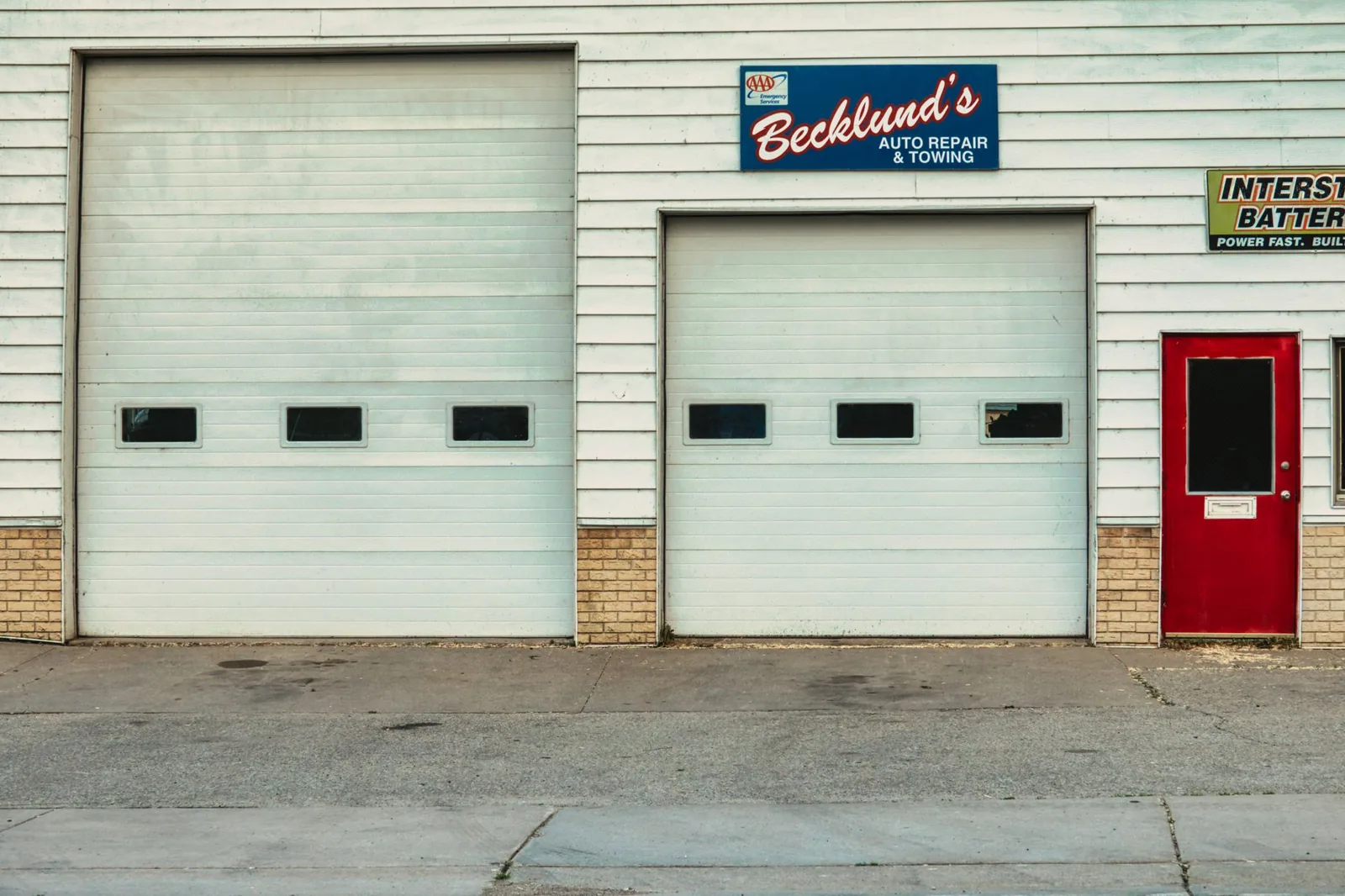How much does a garage door cost to repair — a technician replacing a broken torsion spring above the door
