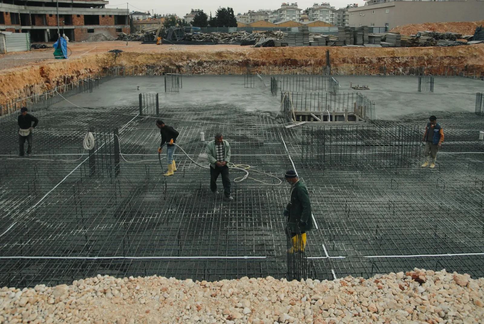 Workers leveling and screeding a large residential concrete slab