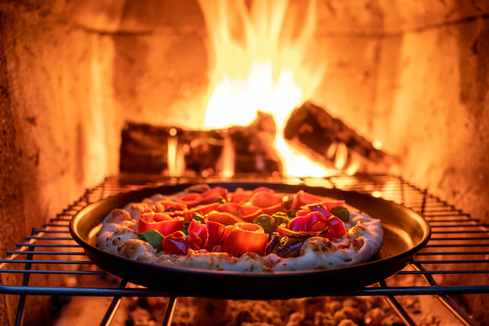 A completed brick pizza oven with a chimneystack in an outdoor kitchen